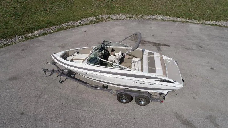 Slide: The Image of 2019 Crownline 215 SS boat on trailer, parked on paved surface. - 4