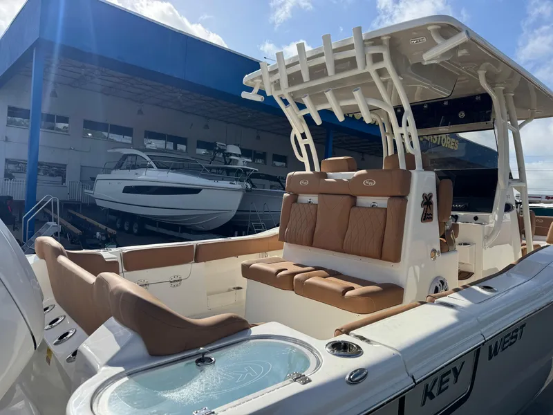 Slide: The Image of 2025 Key West 291 FS boat with tan seating, docked near a marina. - 10