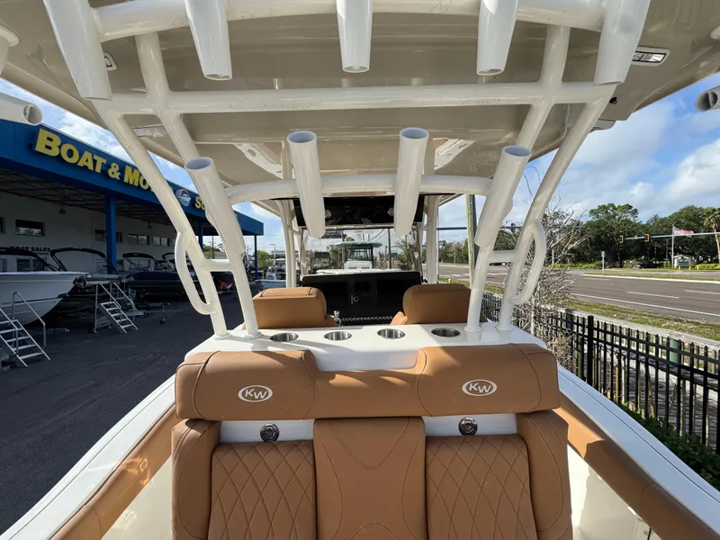 Slide: The Image of 2025 Key West 291 FS boat interior with tan seating and rod holders, at a dealership. - 16