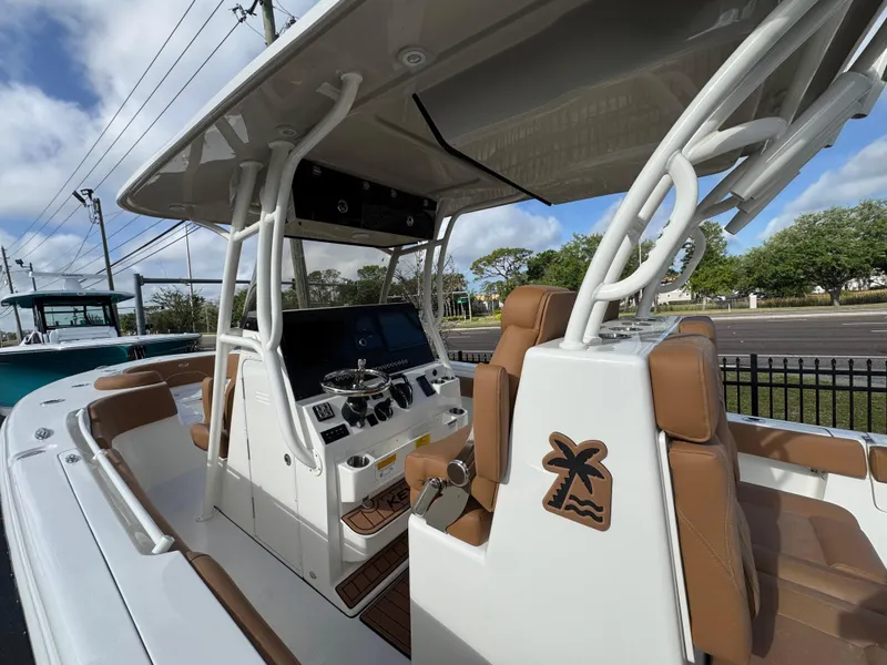 Slide: The Image of 2025 Key West 291 FS boat interior with brown seating and modern dashboard. - 18