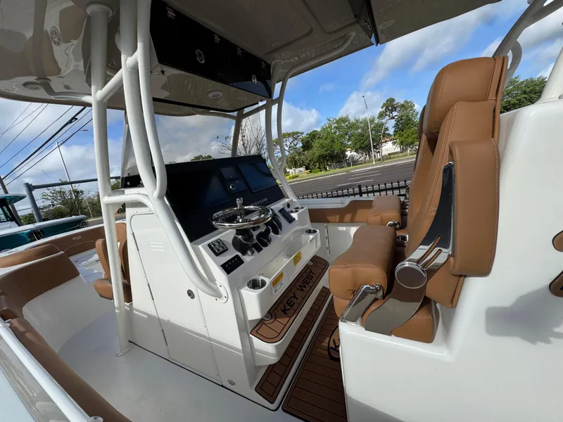 Slide: The Image of 2025 Key West 291 FS boat interior with modern helm and tan seating. - 19