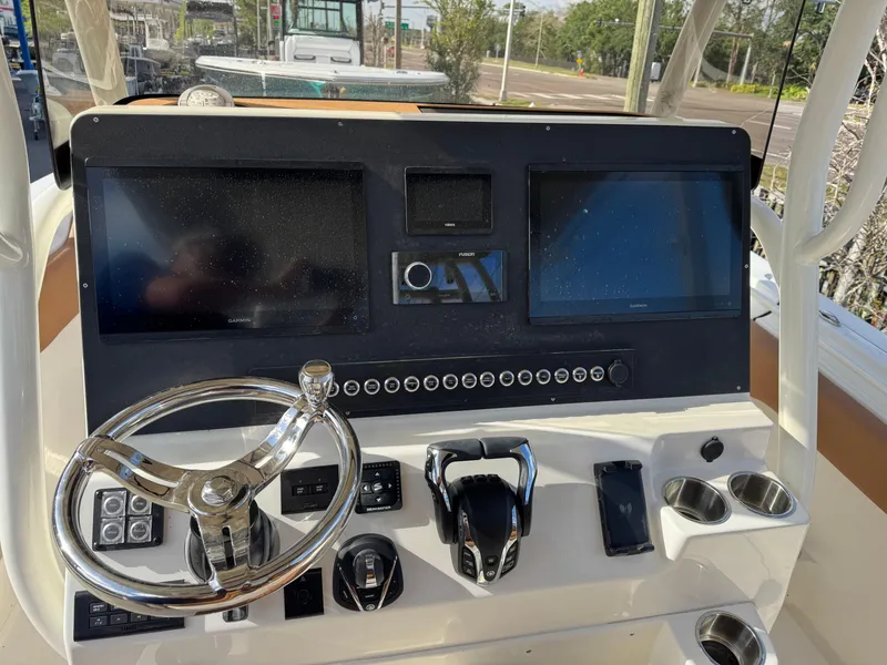 Slide: The Image of 2025 Key West 291 FS boat dashboard with steering wheel and dual screens. - 21