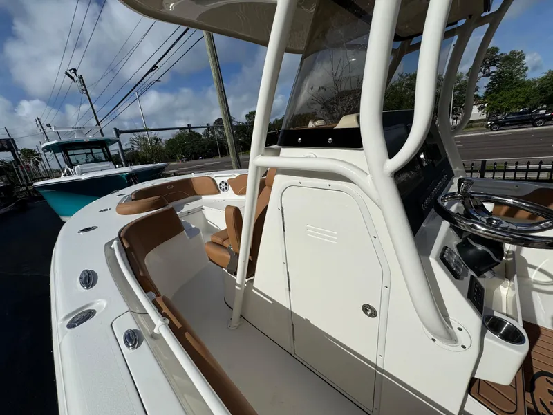 Slide: The Image of 2025 Key West 291 FS boat interior with helm, seating, and console under a clear sky. - 22