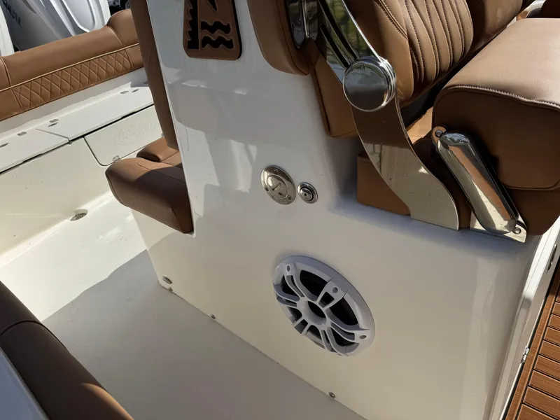Slide: The Image of 2025 Key West 291 FS boat interior with brown seating and speaker. - 34