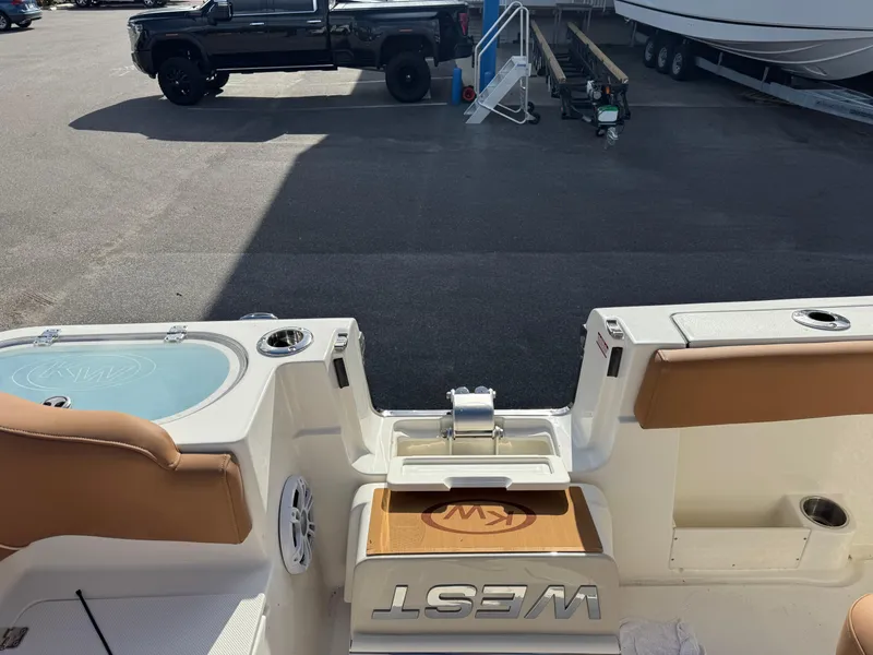 Slide: The Image of 2025 Key West 291 FS boat interior with seating and storage, parked near a black truck. - 37