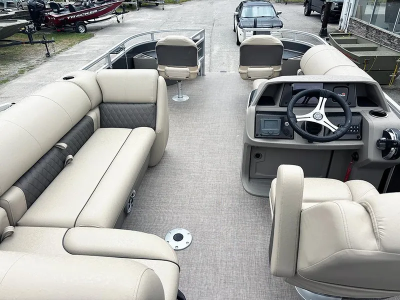 Slide: The Image of 2025 Sun Tracker Fishin' Barge 20 DLX interior with beige seating and steering console. - 10