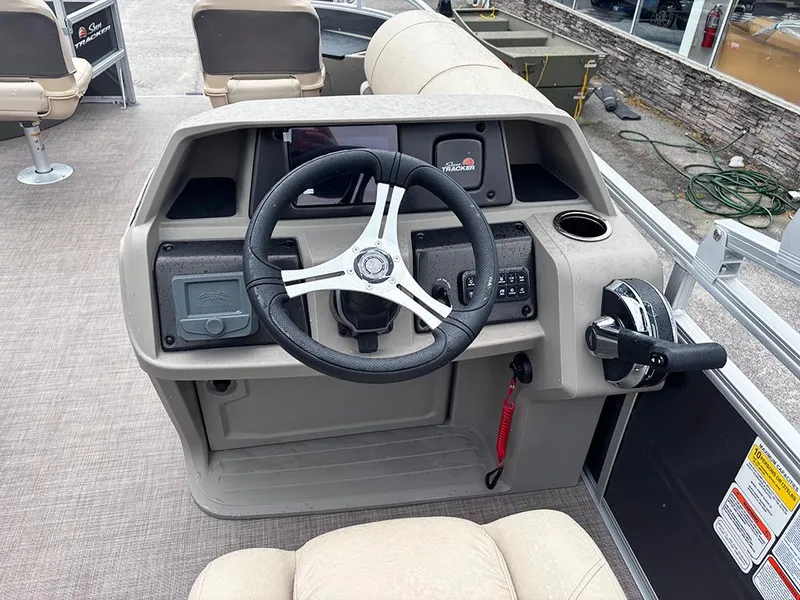 Slide: The Image of 2025 Sun Tracker Fishin' Barge 20 DLX boat console with steering wheel and controls. - 11