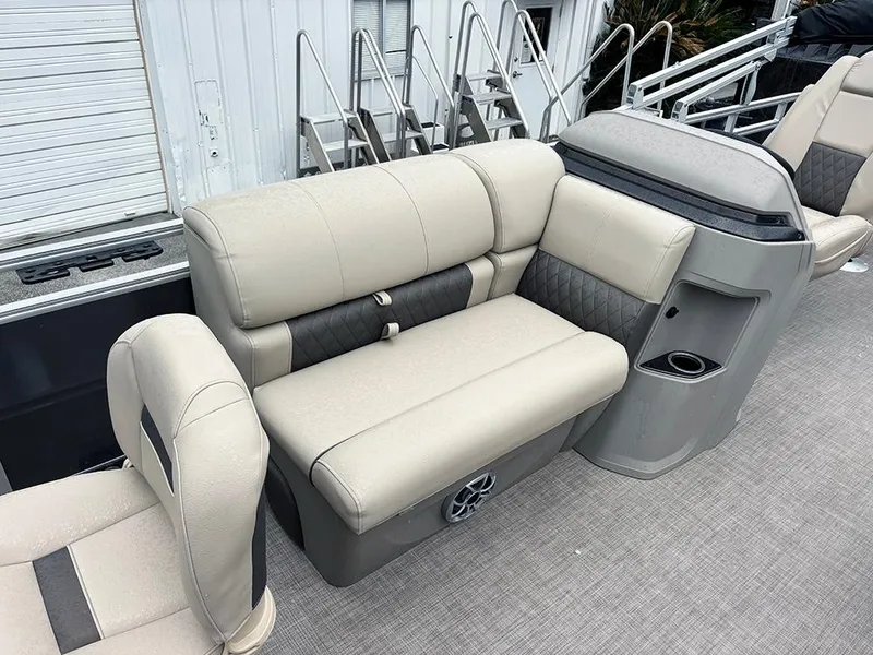 Slide: The Image of 2025 Sun Tracker Fishin' Barge 20 DLX interior seating with beige upholstery and storage compartments. - 15