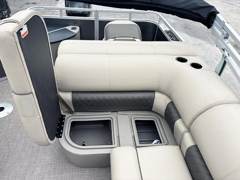 Slide: The Image of 2025 Sun Tracker Fishin' Barge 20 DLX interior with beige seating and storage compartments. - 19