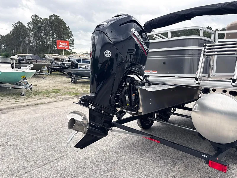 Slide: The Image of 2025 Sun Tracker Fishin' Barge 20 DLX with Mercury outboard motor in storage lot. - 23