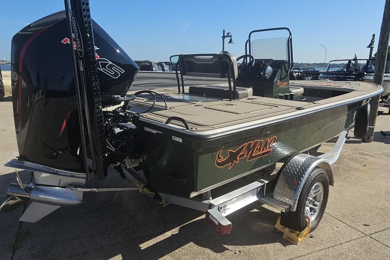 Slide: The Image of 2025 Mako 18 Pro Skiff Backwater Edition boat on trailer, featuring powerful outboard motor. - 2