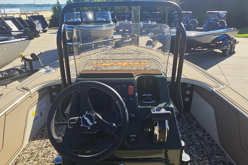 Slide: The Image of 2025 Mako 18 Pro Skiff Backwater Edition boat interior with steering wheel and controls. - 8