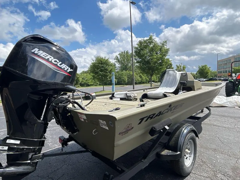 Slide: The Image of 2025 Tracker Grizzly 1754 SC boat with Mercury engine on trailer, outdoors. - 2