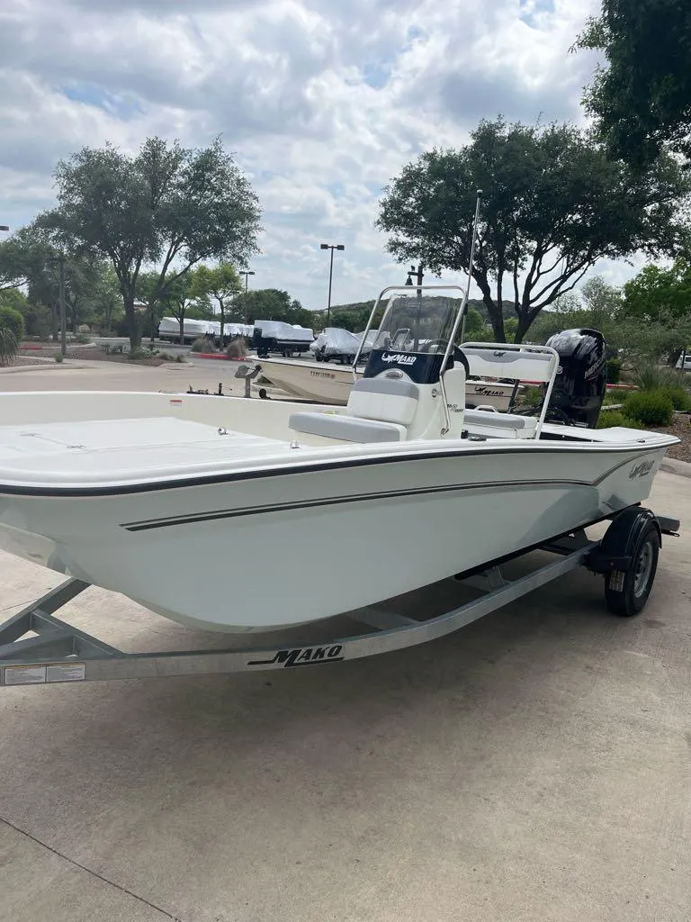 Slide: The Image of 2025 Mako Pro Skiff 17 CC boat on trailer, parked outdoors under cloudy sky. - 0