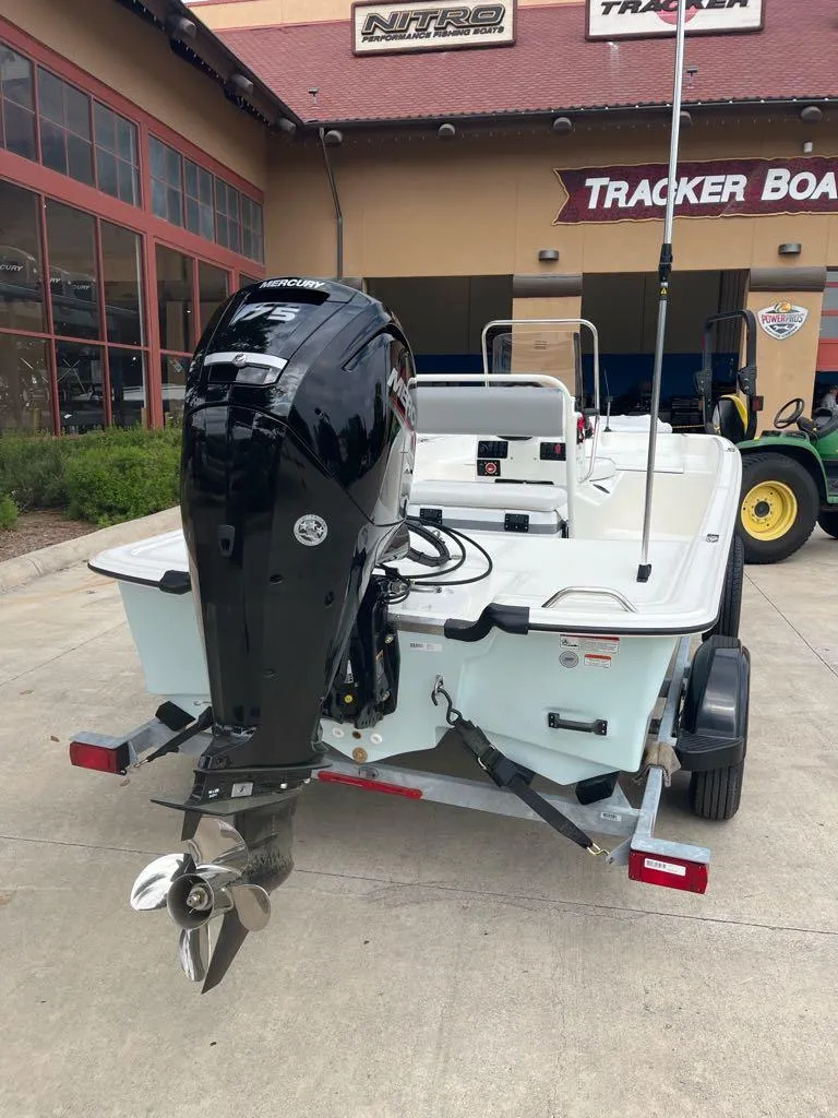 Slide: The Image of 2025 Mako Pro Skiff 17 CC boat with Mercury outboard motor, displayed at Tracker Boats dealership. - 2