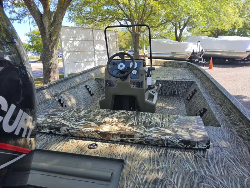 Slide: The Image of 2025 Tracker Grizzly 2072 CC boat with camouflage interior, parked outdoors. - 3