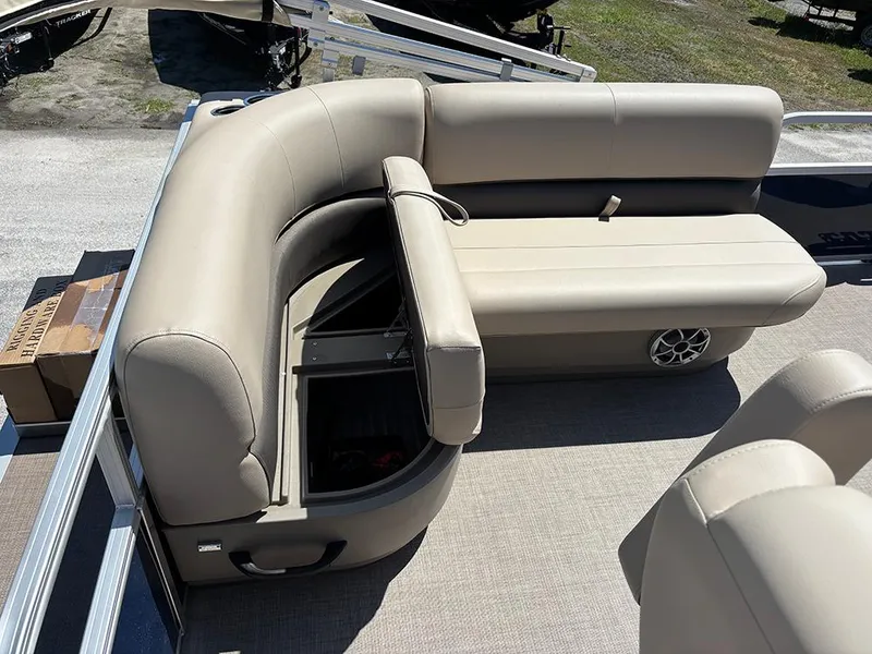 Slide: The Image of 2025 Sun Tracker Bass Buggy 16 XL Select pontoon boat with beige seating and storage compartment. - 16