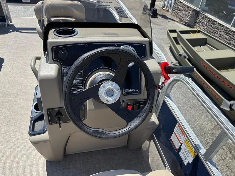 Slide: The Image of 2025 Sun Tracker Bass Buggy 16 XL Select steering console with cup holder and controls. - 17