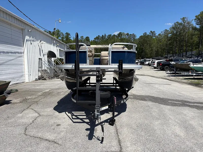 Slide: The Image of 2025 Sun Tracker Bass Buggy 16 XL Select pontoon boat on trailer in outdoor lot. - 4