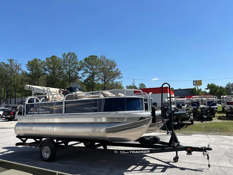 Slide: The Image of 2025 Sun Tracker Bass Buggy 16 XL Select pontoon boat on trailer, outdoor display. - 5