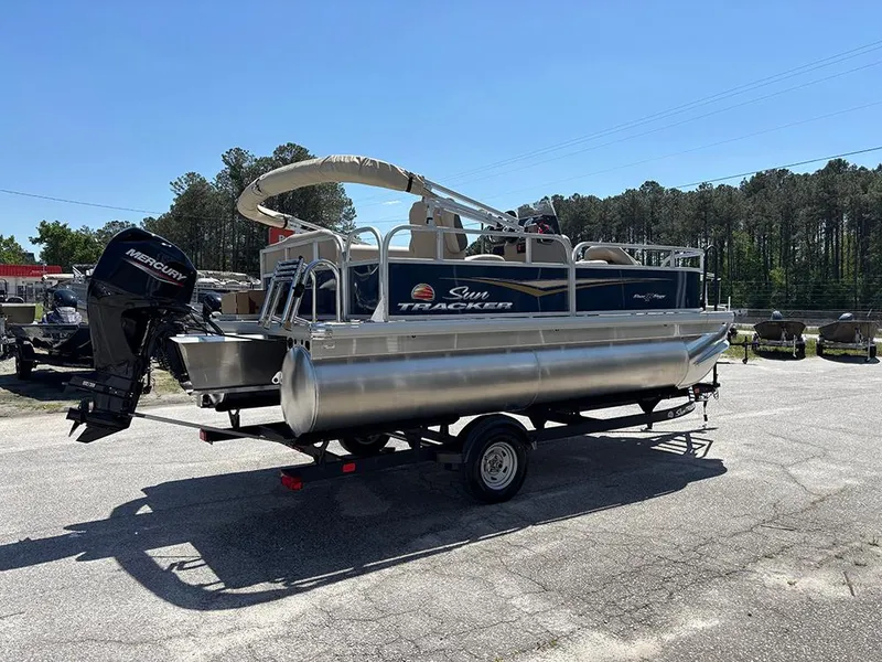 Slide: The Image of 2025 Sun Tracker Bass Buggy 16 XL Select pontoon boat on trailer, outdoors. - 7