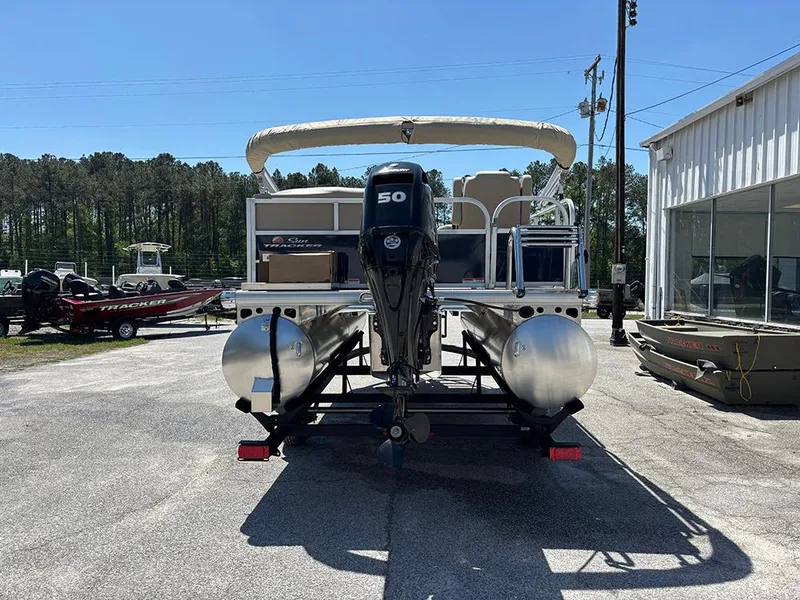 Slide: The Image of 2025 Sun Tracker Bass Buggy 16 XL Select pontoon boat with 50 HP engine, parked outdoors. - 8