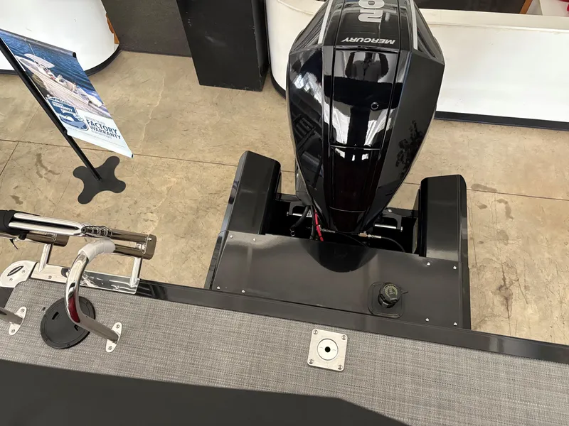 Slide: The Image of 2025 Regency 230 DL3 boat with Mercury outboard motor, displayed indoors. - 3