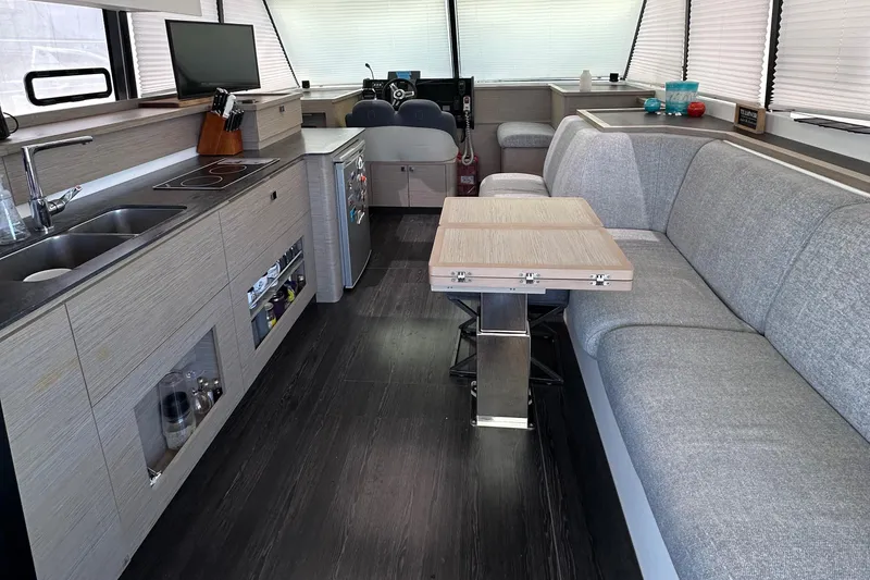 Slide: The Image of Luxurious 2021 Fountaine Pajot MY4.S yacht interior with plush seating and marina view. - 2