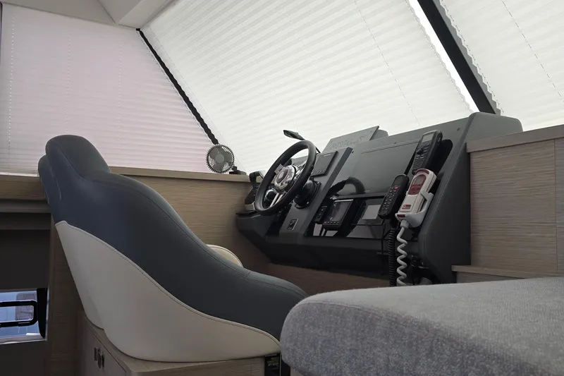 Slide: The Image of 2021 Fountaine Pajot MY4.S helm station with modern controls and seating. - 7