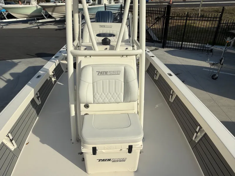 Slide: The Image of 2022 Pathfinder 2500 Hybrid boat interior with white seating and console. - 10