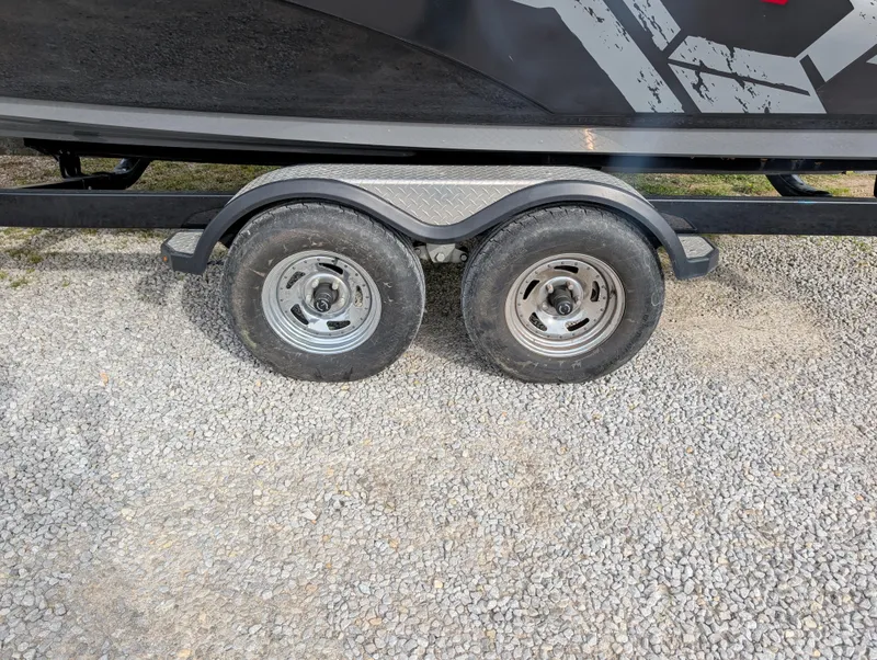 Slide: The Image of Trailer wheels of a 2017 Yamaha Boats 242X E-Series on gravel. - 10