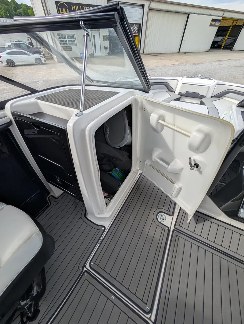 Slide: The Image of 2017 Yamaha Boats 242X E-Series interior with open storage compartment and sleek design. - 24
