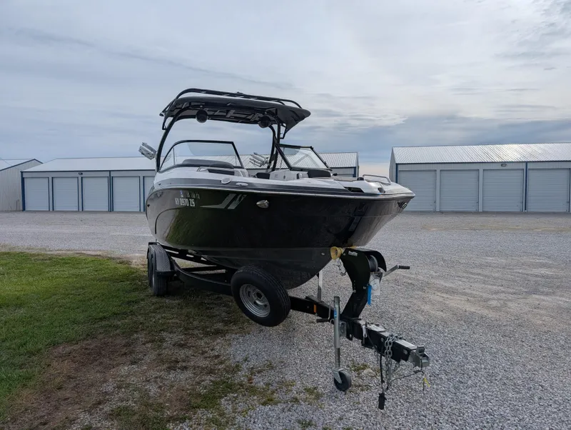 Slide: The Image of 2017 Yamaha Boats 242X E-Series on trailer near storage units. - 3