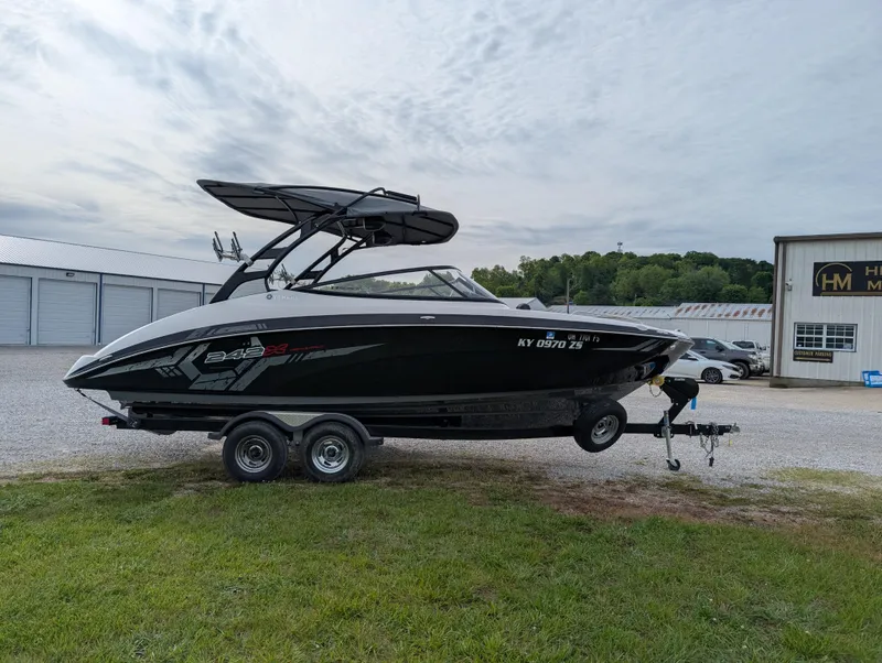 Slide: The Image of 2017 Yamaha Boats 242X E-Series on trailer, parked outdoors near storage facility. - 4