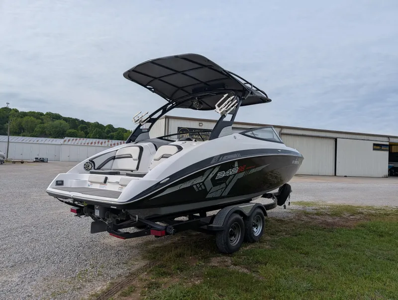 Slide: The Image of 2017 Yamaha Boats 242X E-Series on trailer, parked outdoors near a warehouse. - 5