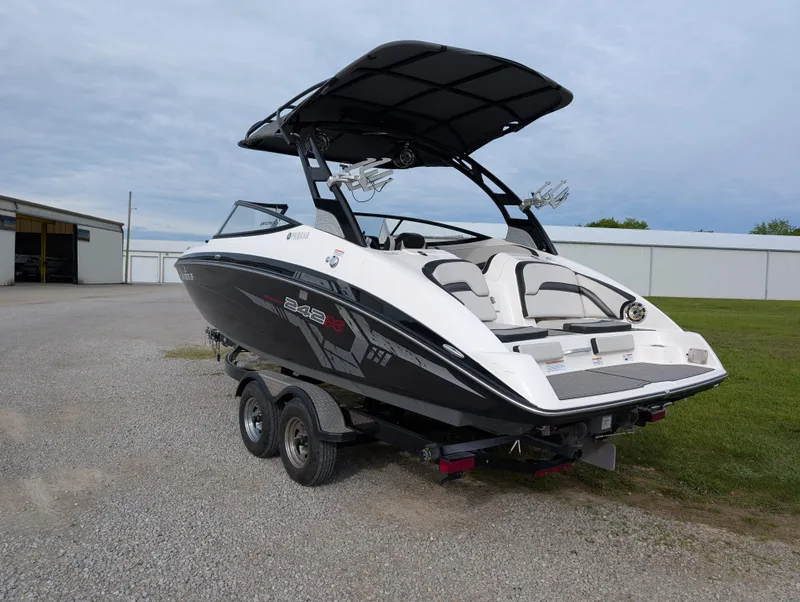 Slide: The Image of 2017 Yamaha Boats 242X E-Series on trailer, black and white design, parked outdoors. - 7