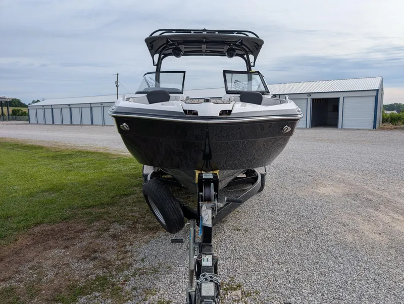 Slide: The Image of 2017 Yamaha Boats 242X E-Series on trailer, parked outdoors near storage buildings. - 8