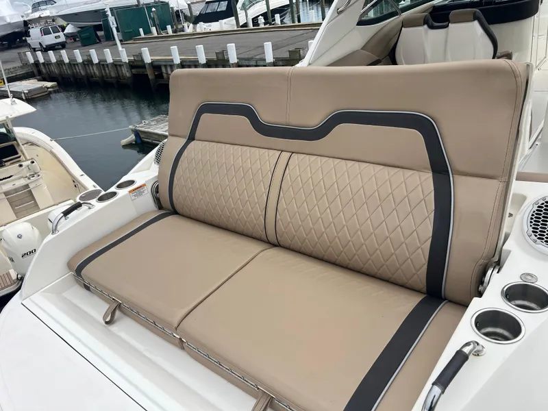 Slide: The Image of 2017 Sea Ray SLX 350 OB boat with tan leather seating at a marina. - 15
