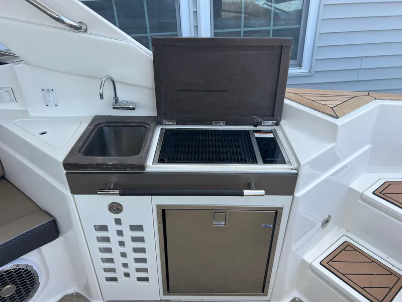 Slide: The Image of Outdoor kitchen area on a 2017 Sea Ray SLX 350 OB boat with sink and grill. - 16