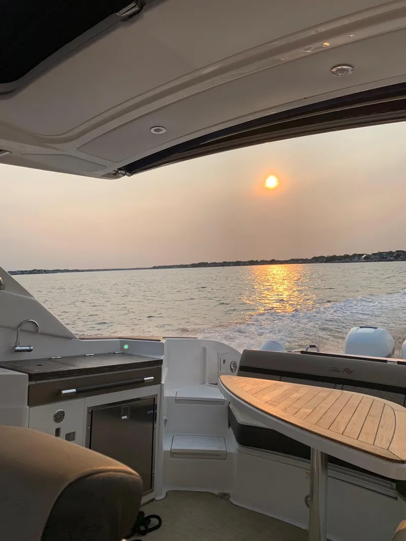 Slide: The Image of 2017 Sea Ray SLX 350 OB boat interior with sunset view over water. - 19