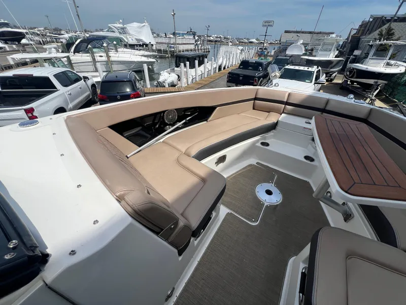 Slide: The Image of 2017 Sea Ray SLX 350 OB boat with spacious seating at a marina. - 21