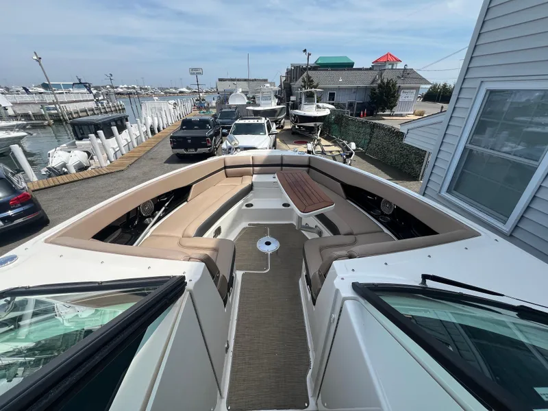 Slide: The Image of 2017 Sea Ray SLX 350 OB boat with spacious seating at a marina dock. - 23