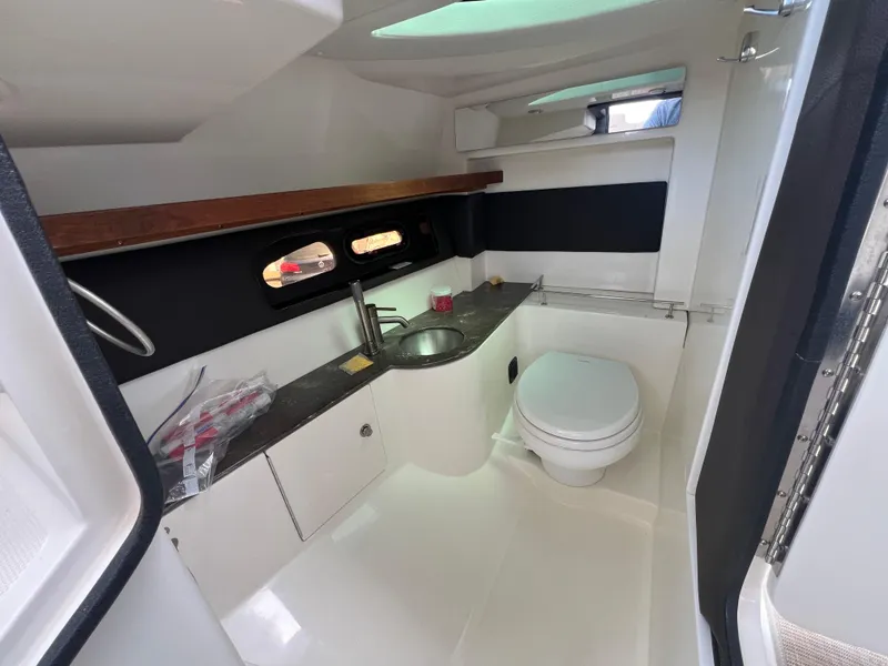 Slide: The Image of 2017 Sea Ray SLX 350 OB boat interior with sink, toilet, and storage. - 26