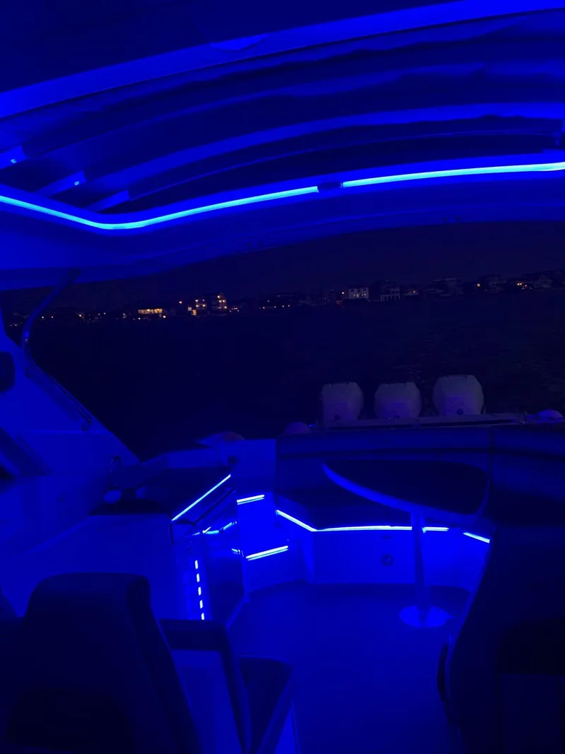 Slide: The Image of 2017 Sea Ray SLX 350 OB boat interior with blue LED lighting at night. - 29