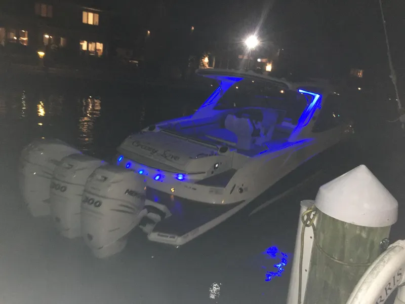 Slide: The Image of 2017 Sea Ray SLX 350 OB boat with blue LED lights docked at night. - 30