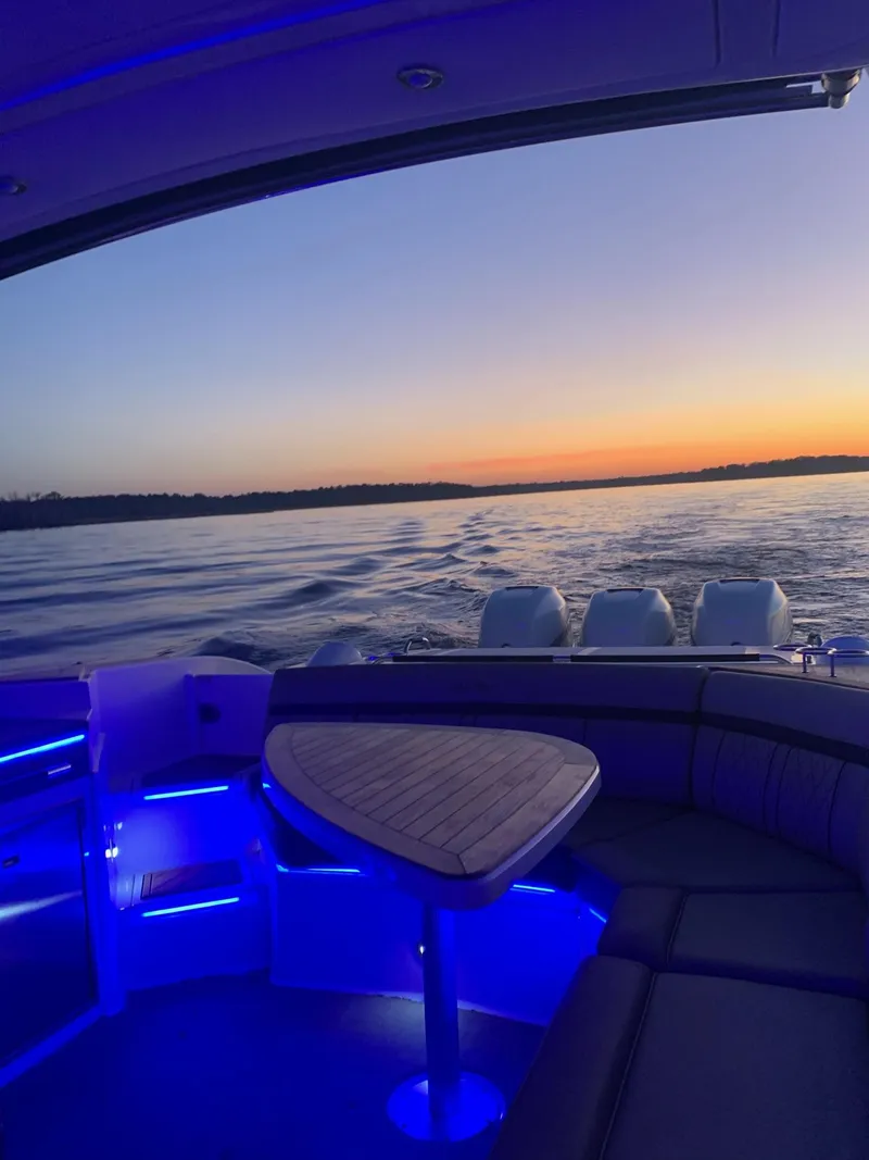 Slide: The Image of 2017 Sea Ray SLX 350 OB boat at sunset, featuring blue LED interior lighting. - 31