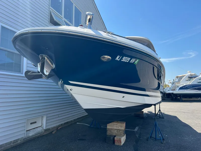 Slide: The Image of 2017 Sea Ray SLX 350 OB boat on stands, blue and white hull, outdoor setting. - 34
