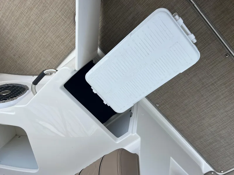 Slide: The Image of 2017 Sea Ray SLX 350 OB interior storage compartment with white lid and speaker. - 47