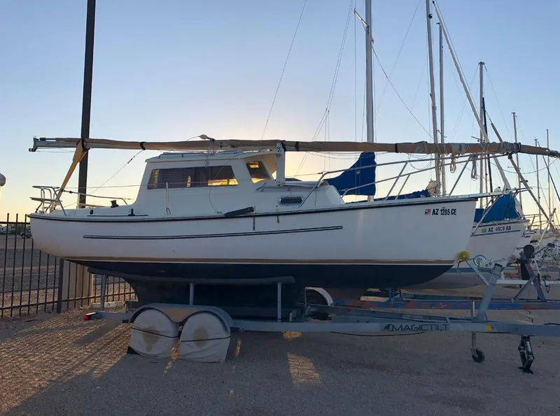 Slide: The Image of 2022 Com-Pac CP 23 Pilothouse sailboat on trailer at marina during sunset. - 1