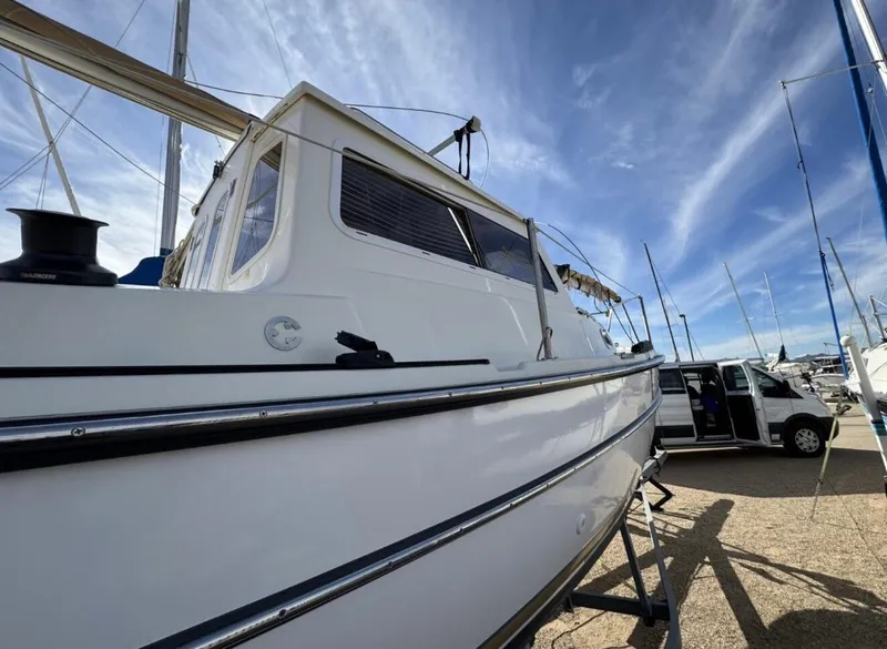 Slide: The Image of 2022 Com-Pac CP 23 Pilothouse sailboat on display under a clear blue sky. - 7